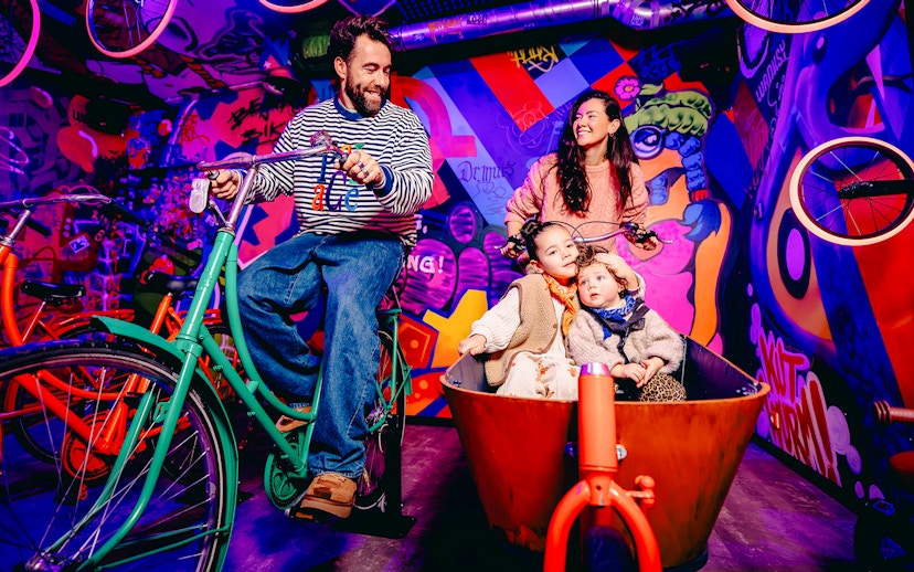 Guests enjoying a colorful bike ride in a vibrant, graffiti-filled space in Holland.