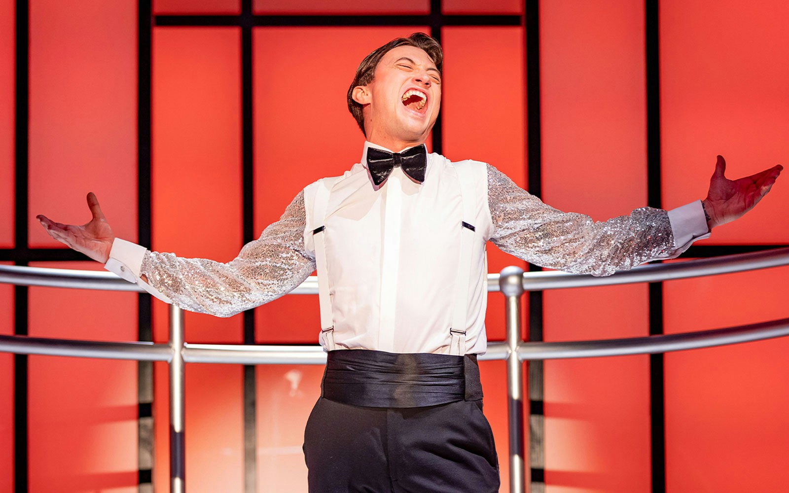 Performer singing passionately on stage in Titanique show.