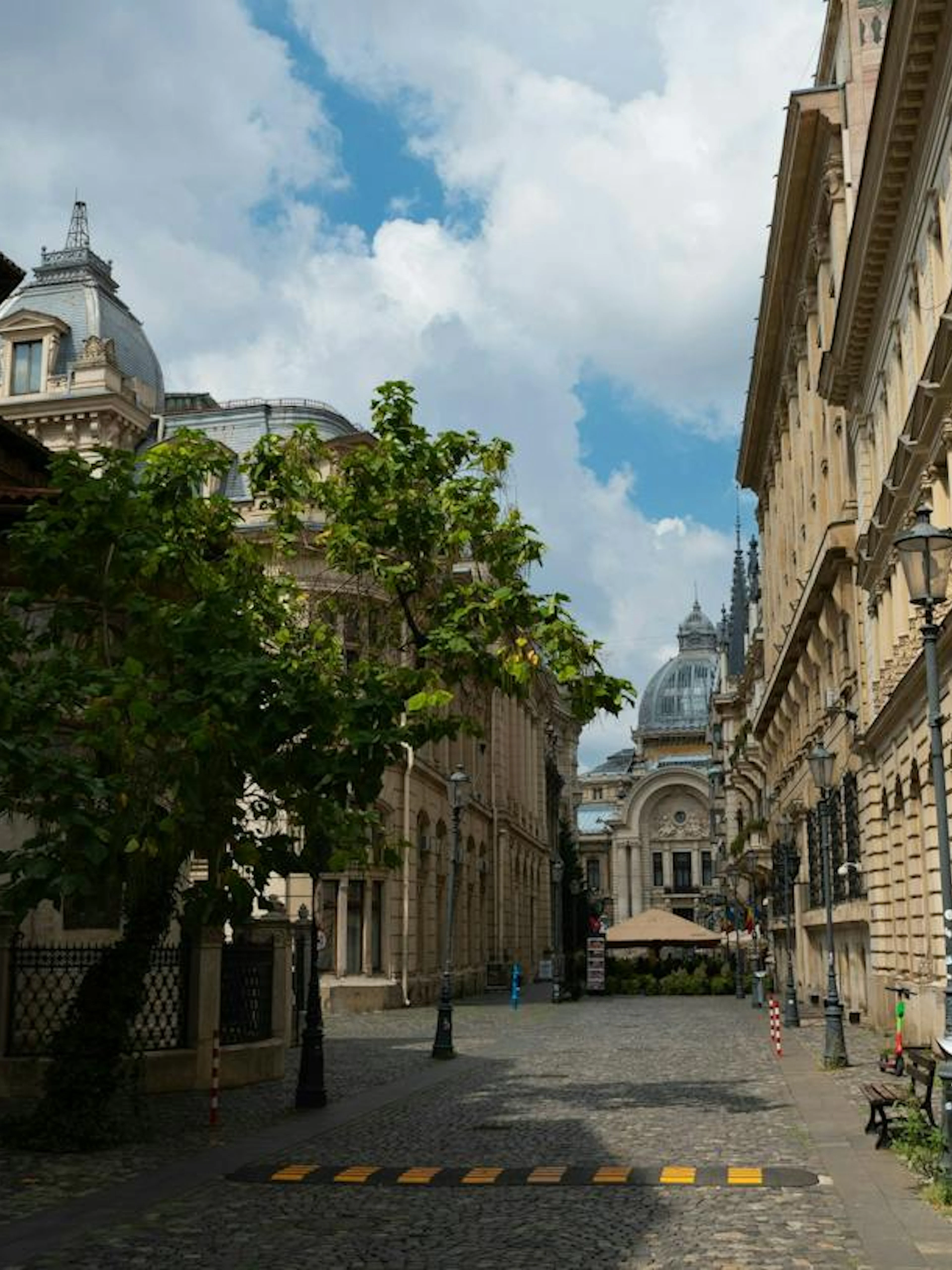 Historic street in Bucharest with ornate buildings and cobblestone path on the Beer Trail exploration game.