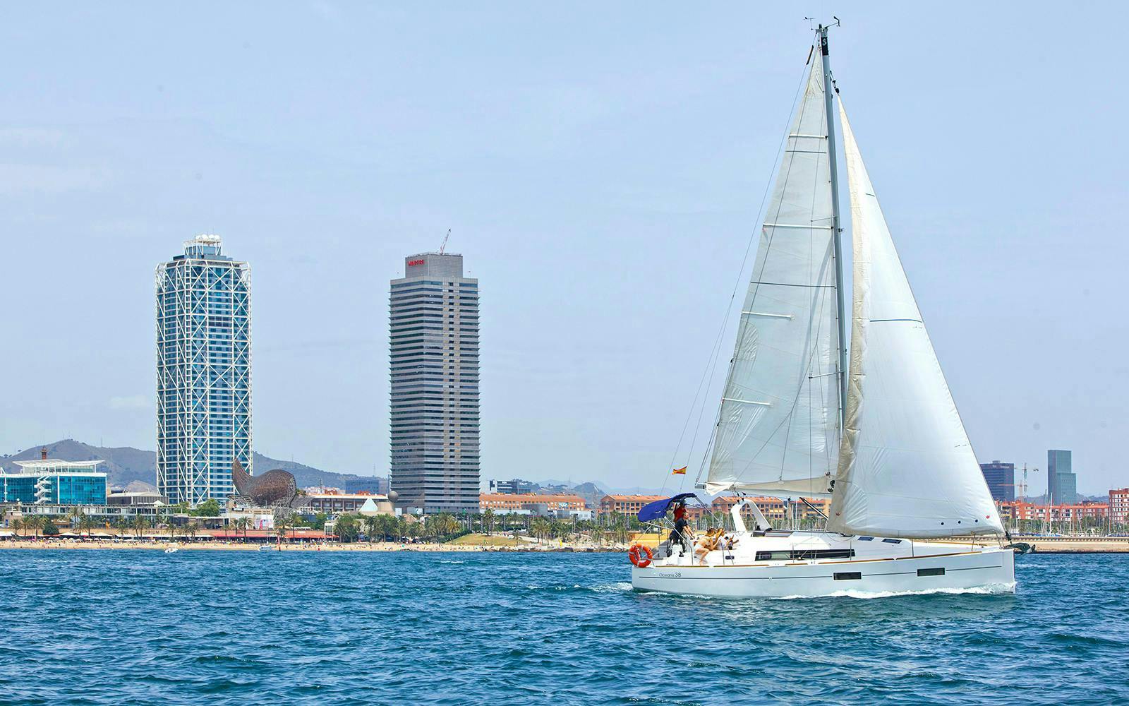 Sailboat on Barcelona coast with city skyline in background during 2-hour tour.