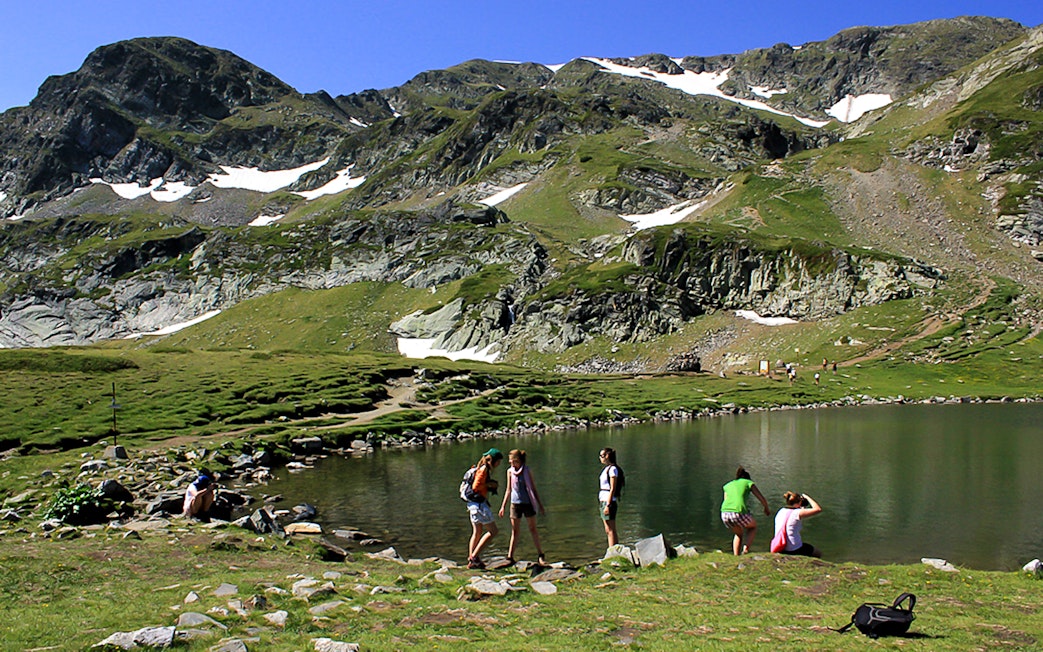 Cable car view during Rila Monastery & Seven Rila Lakes tour with hikers by a lake.