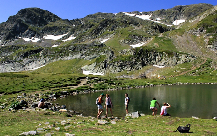 Cable car view during Rila Monastery & Seven Rila Lakes tour with hikers by a lake.