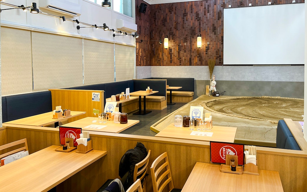 Sumo wrestling arena with dining tables in a Japanese restaurant setting.