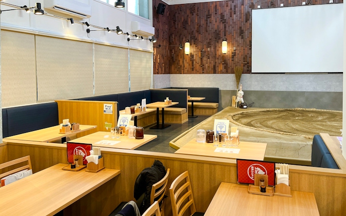 Sumo wrestling arena with dining tables in a Japanese restaurant setting.