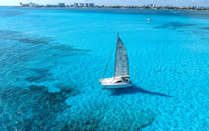 Catamaran sailing on turquoise waters near Isla Mujeres, Mexico.