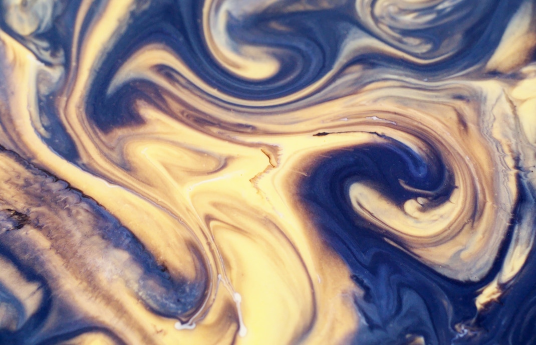 Blur blue yellow golden color chemical water marble particles enamel texture on abstract background.