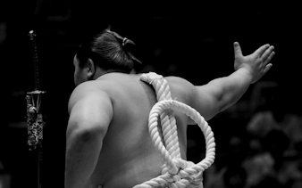 Sumo wrestler preparing for match at Fukuoka Grand Sumo Tournament.