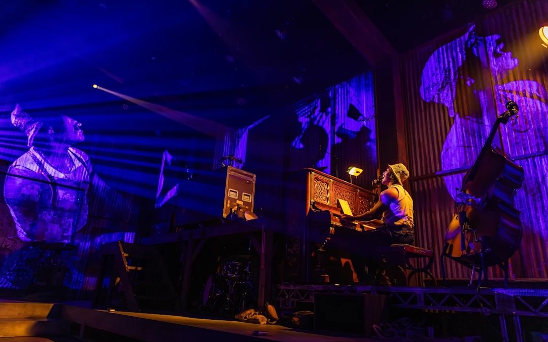 Performer playing piano during Mexodus the Musical on Broadway stage.