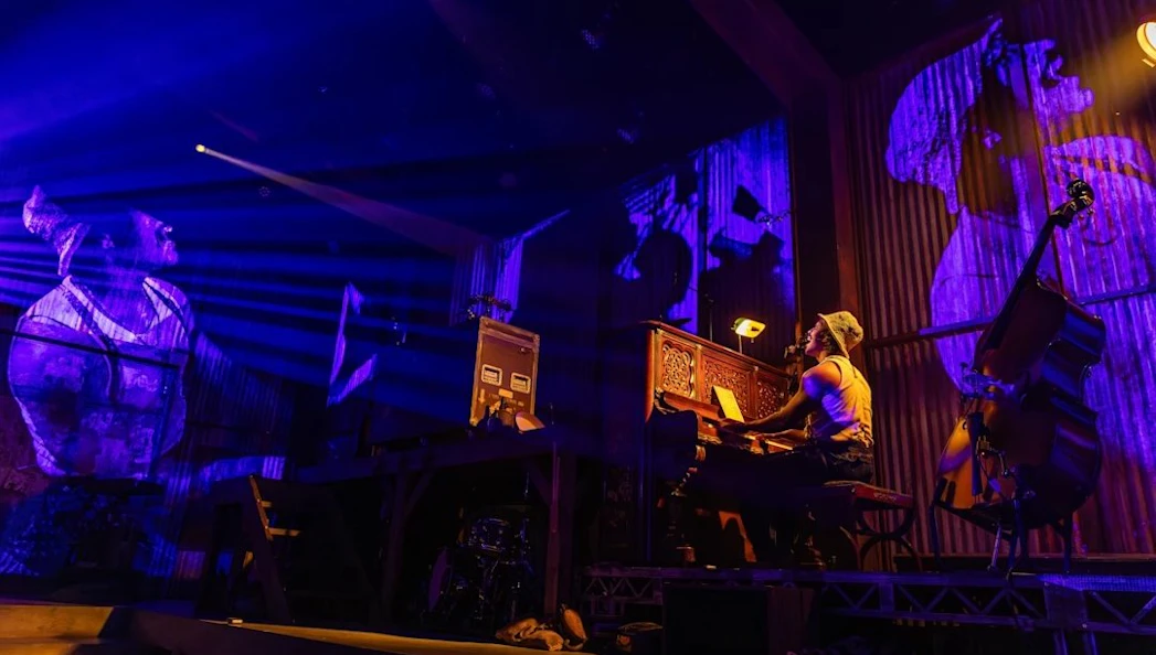 Performer playing piano during Mexodus the Musical on Broadway stage.