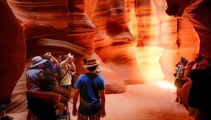 Tourists photographing the sandstone formations in Antelope Canyon, Arizona.