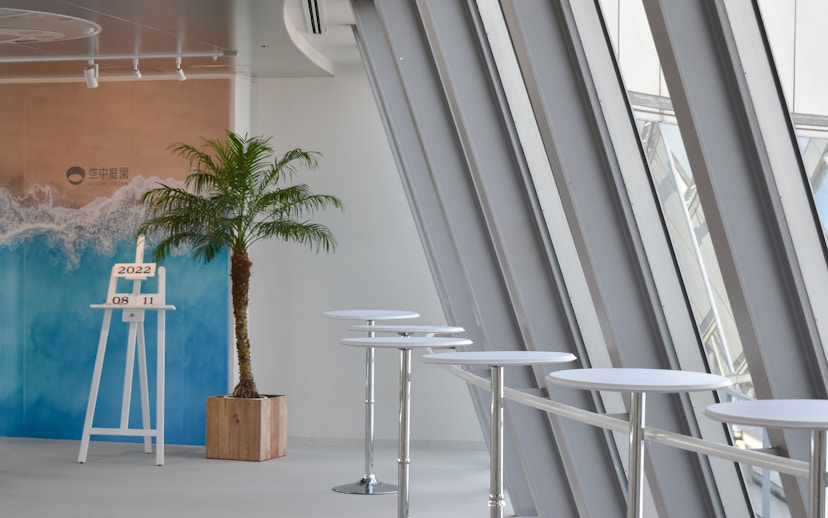 Umeda Sky Building interior with palm plant and modern tables, Osaka.