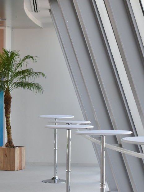 Umeda Sky Building interior with palm plant and modern tables, Osaka.