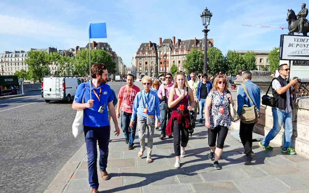Guide leading group through Paris streets on Notre Dame tour.