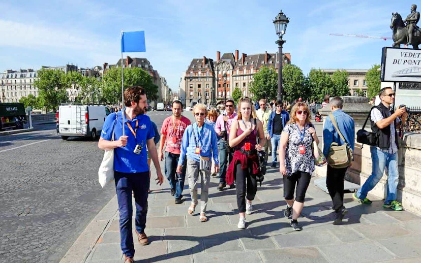 Guide leading group through Paris streets on Notre Dame tour.