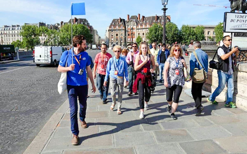Guide leading group through Paris streets on Notre Dame tour.