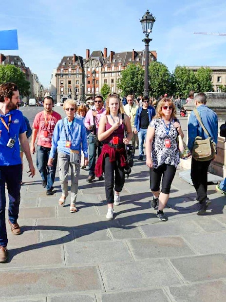Guide leading group through Paris streets on Notre Dame tour.