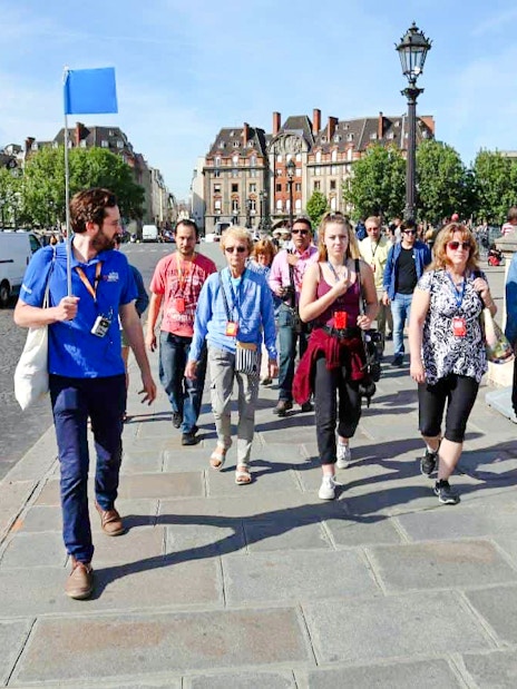 Guide leading group through Paris streets on Notre Dame tour.
