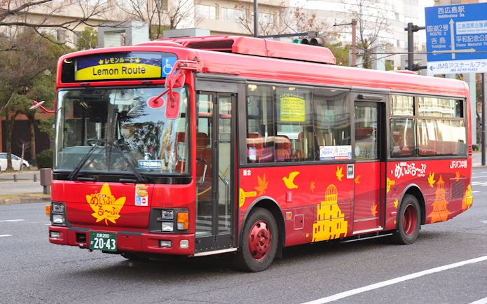 Red Hiroshima tourist bus on Lemon Route with city landmarks depicted.