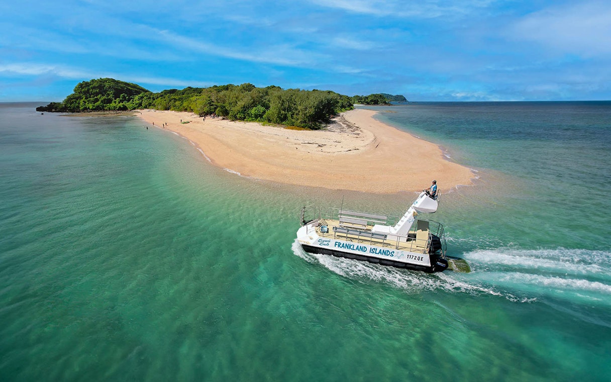Boat nearing sandy shore of Frankland Islands, Australia.