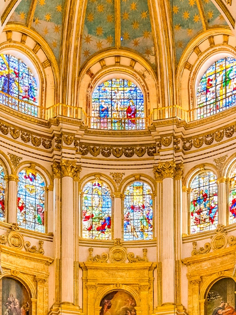 Granada Cathedral interior with colorful stained glass windows.