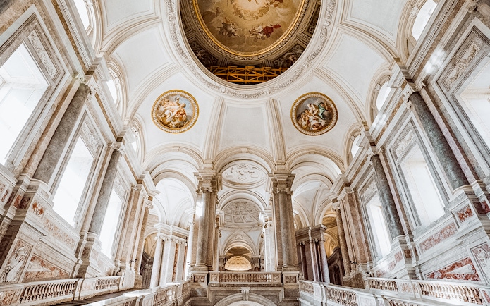 Royal Palace of Caserta vaulted ceiling with ornate frescoes and grand columns.
