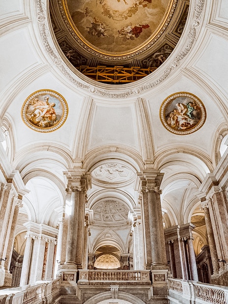 Royal Palace of Caserta vaulted ceiling with ornate frescoes and grand columns.