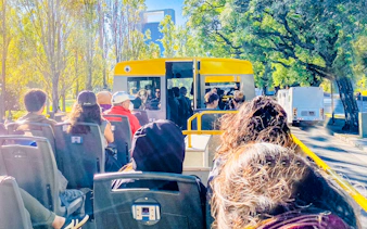 Open-top tour bus in Buenos Aires with passengers enjoying city views.