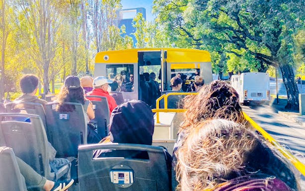 Open-top tour bus in Buenos Aires with passengers enjoying city views.