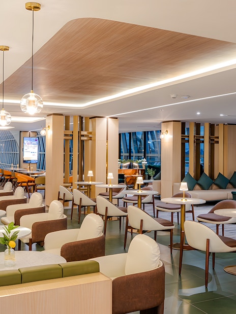 Coral Cosmo Lounge seating area with tables and chairs, Concourse C, Bangkok airport, Thailand.