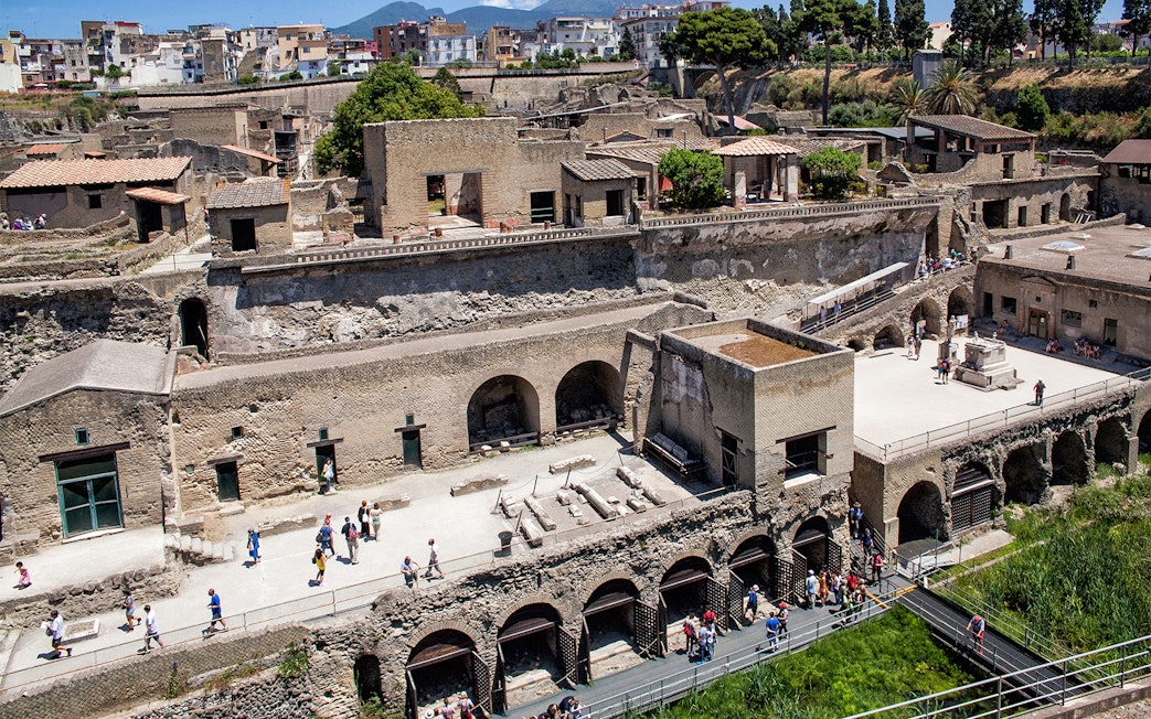 Herculaneum ruins with tourists exploring the ancient site, Italy.