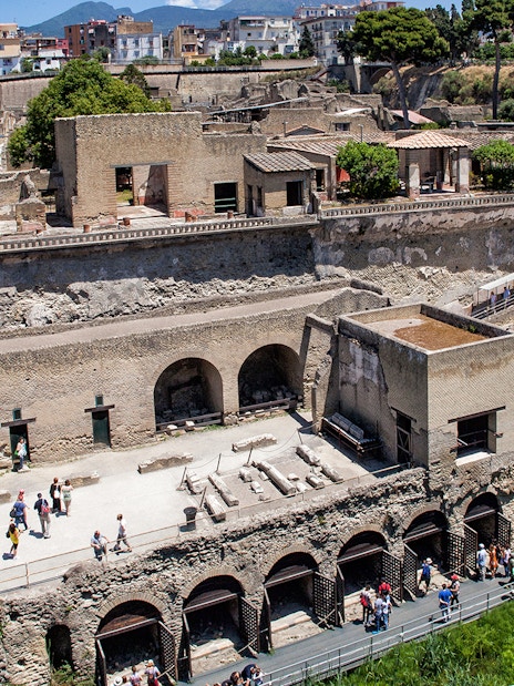 Herculaneum ruins with tourists exploring the ancient site, Italy.