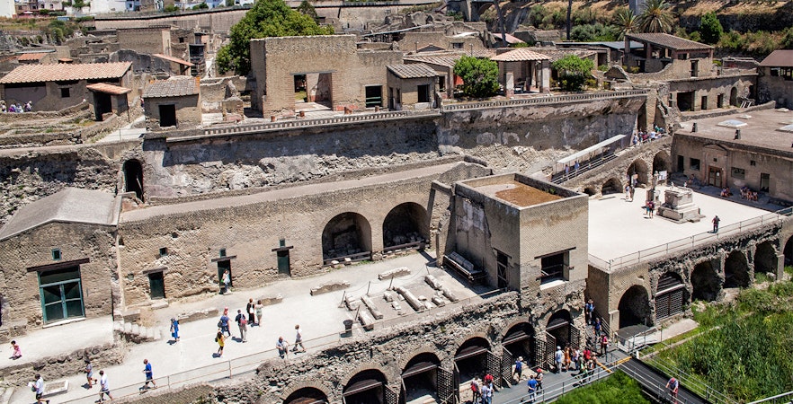 Herculaneum ruins with tourists exploring the ancient site, Italy.