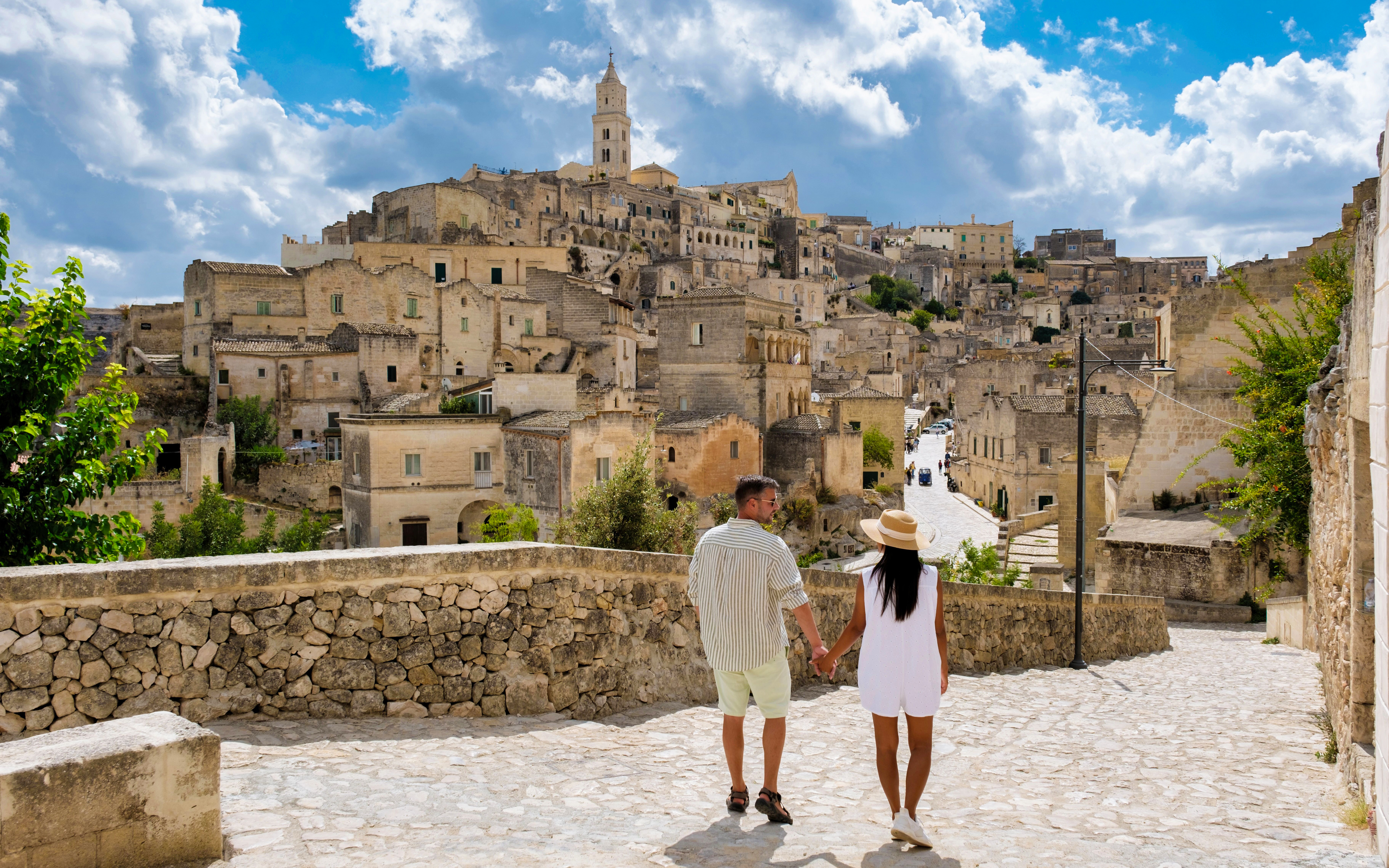 Couple walking through historic stone streets of Matera, Italy.