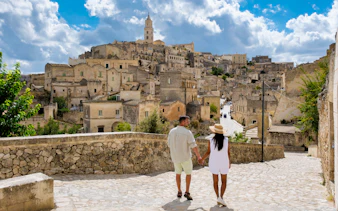 Couple walking through historic stone streets of Matera, Italy.