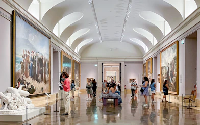 Visitors exploring art galleries inside the Prado Museum, Madrid.