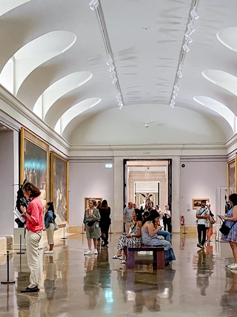 Visitors exploring art galleries inside the Prado Museum, Madrid.