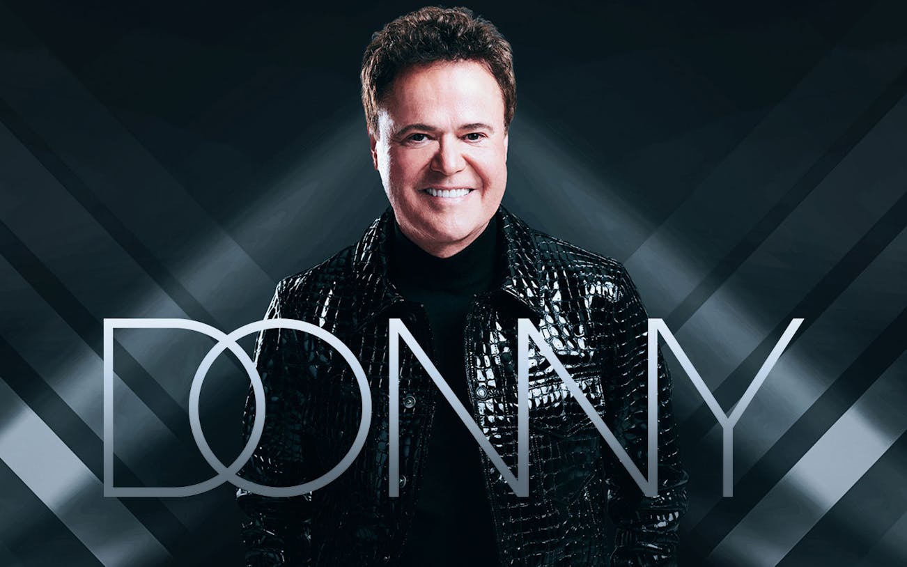 Performer in black jacket with 'Donny' text overlay