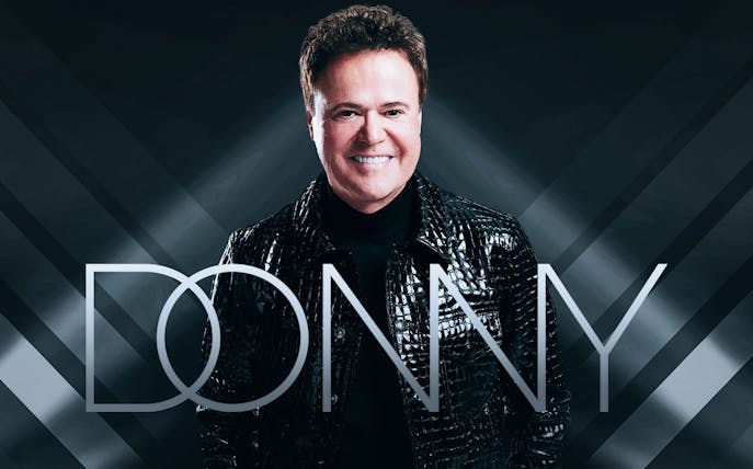 Performer in black jacket with 'Donny' text overlay