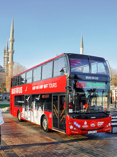 Tourists boarding a red double-decker bus near the Blue Mosque in Istanbul.