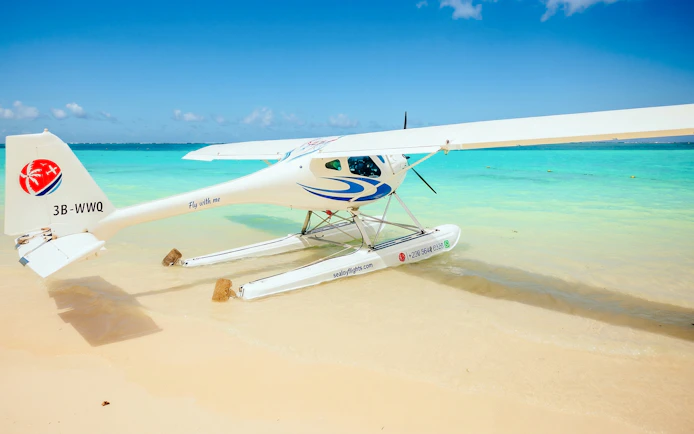 Seaplane on sandy beach with turquoise water, Mauritius.