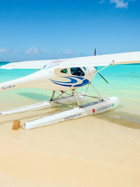 Seaplane on sandy beach with turquoise water, Mauritius.