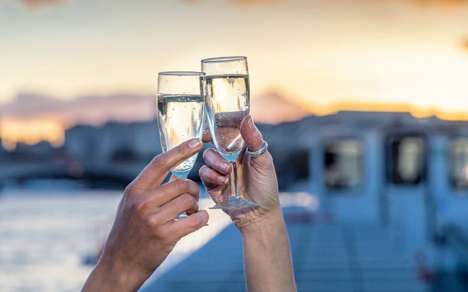 Toasting with sparkling wine on Thames River cruise at sunset.