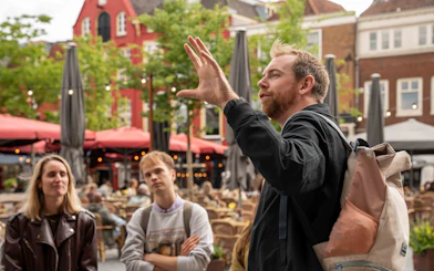 Local guide leading a small group tour in Utrecht city square.
