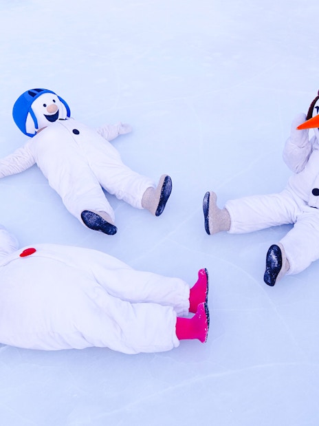 Snowmen in costumes playing on ice at Snowman World, Santa Claus Village.
