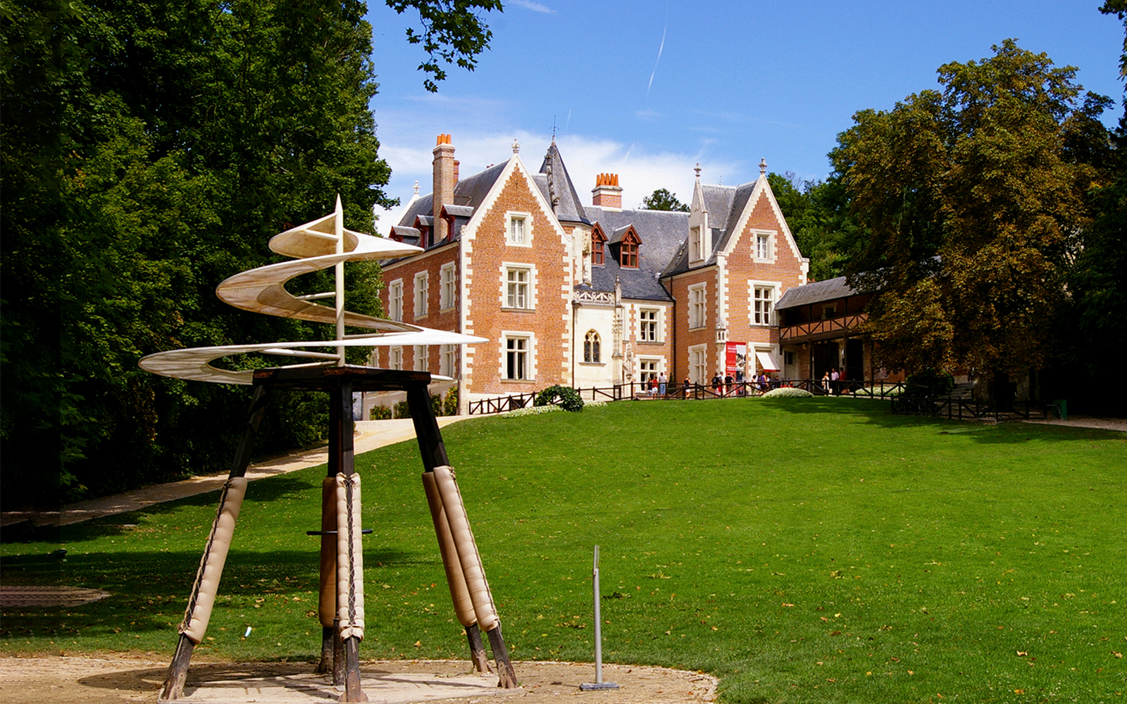 Clos Lucé Castle with spiral sculpture in garden, France.