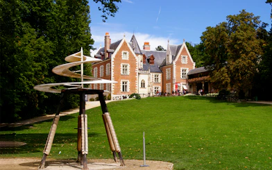 Clos Lucé Castle with spiral sculpture in garden, France.