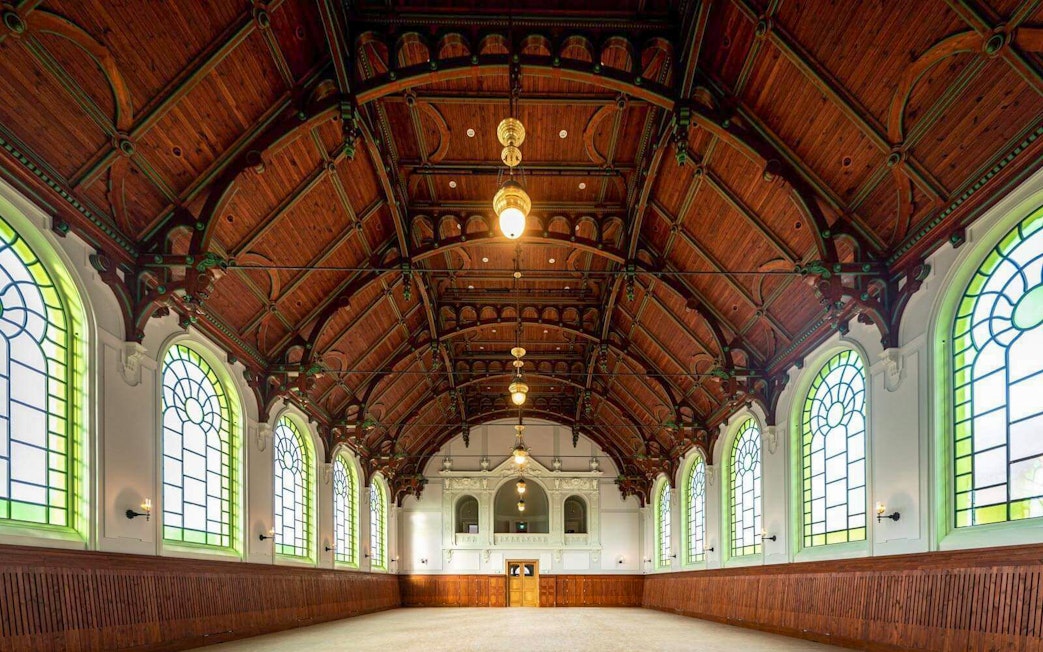 Interior of the Hungarian Royal Guard Riding Hall with arched windows and wooden ceiling in Budapest.