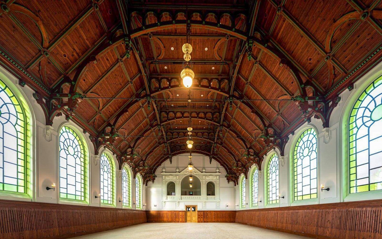 Interior of the Hungarian Royal Guard Riding Hall with arched windows and wooden ceiling in Budapest.