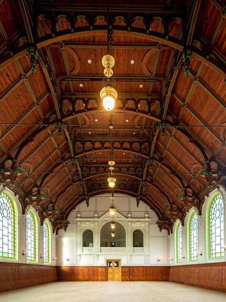 Interior of the Hungarian Royal Guard Riding Hall with arched windows and wooden ceiling in Budapest.