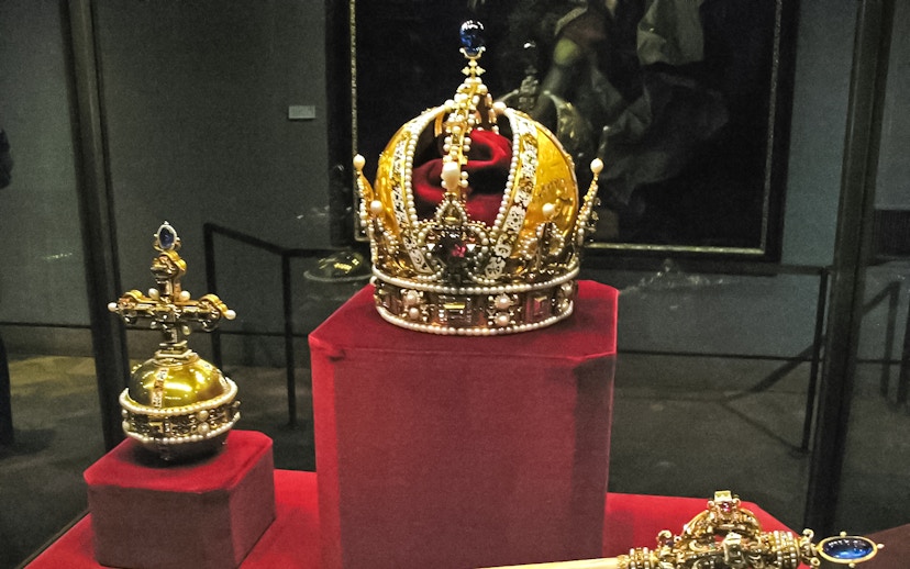 Crown jewels displayed at the Tower of London, featuring an ornate crown and scepter.
